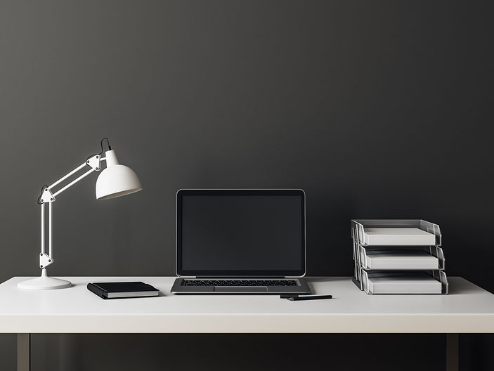 An empty desk with a blank laptop